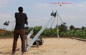 Technik pracownik Zipline uruchamia drone w Muhanga