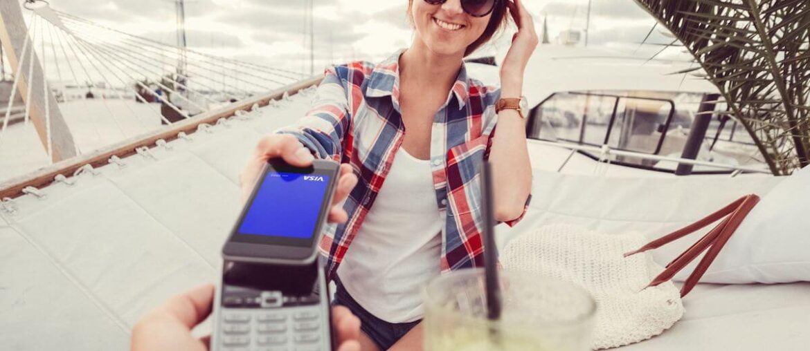 Kobieta płaci telefonen podczas zagranicznych wakacji