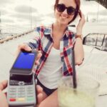 Kobieta płaci telefonen podczas zagranicznych wakacji