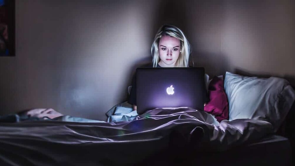 Dziewczyna korzysta z laptopa wieczorową porą