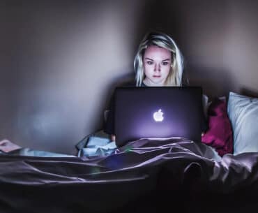 Dziewczyna korzysta z laptopa wieczorową porą